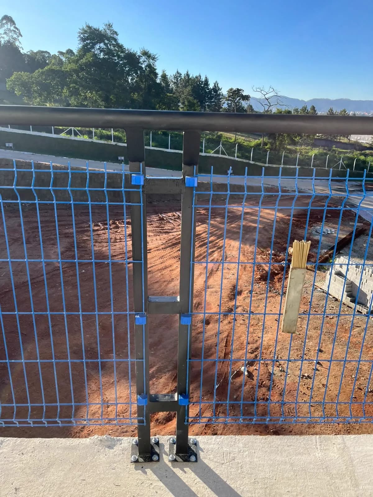 Guarda-corpo metálico com tubo superior, instalado sobre alambrado