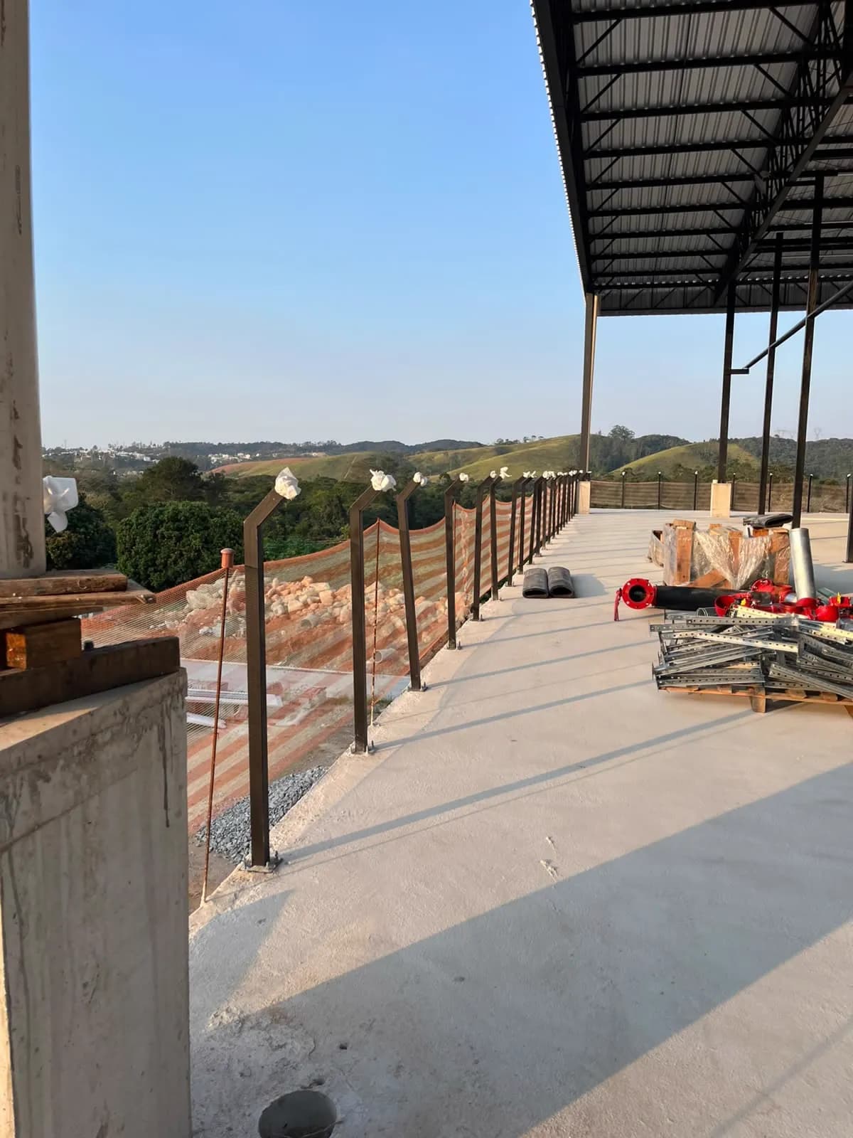 Cobertura de galpão vista de dentro, com terças e guarda-corpo lateral