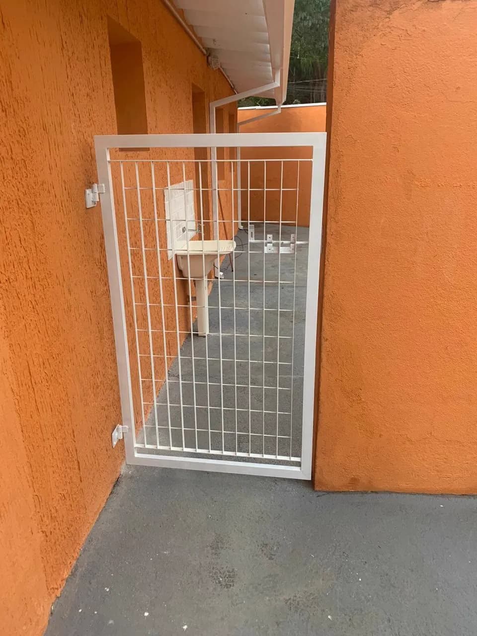 Portão de pedestre em tela soldada, instalado na lateral do prédio